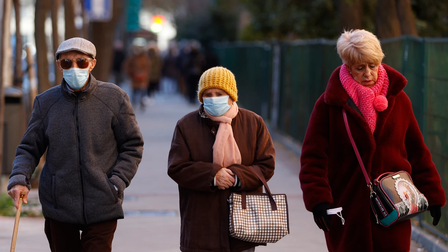 Tres personas pasean por las calles de Madrid Tres personas pasean por las calles de Madrid
