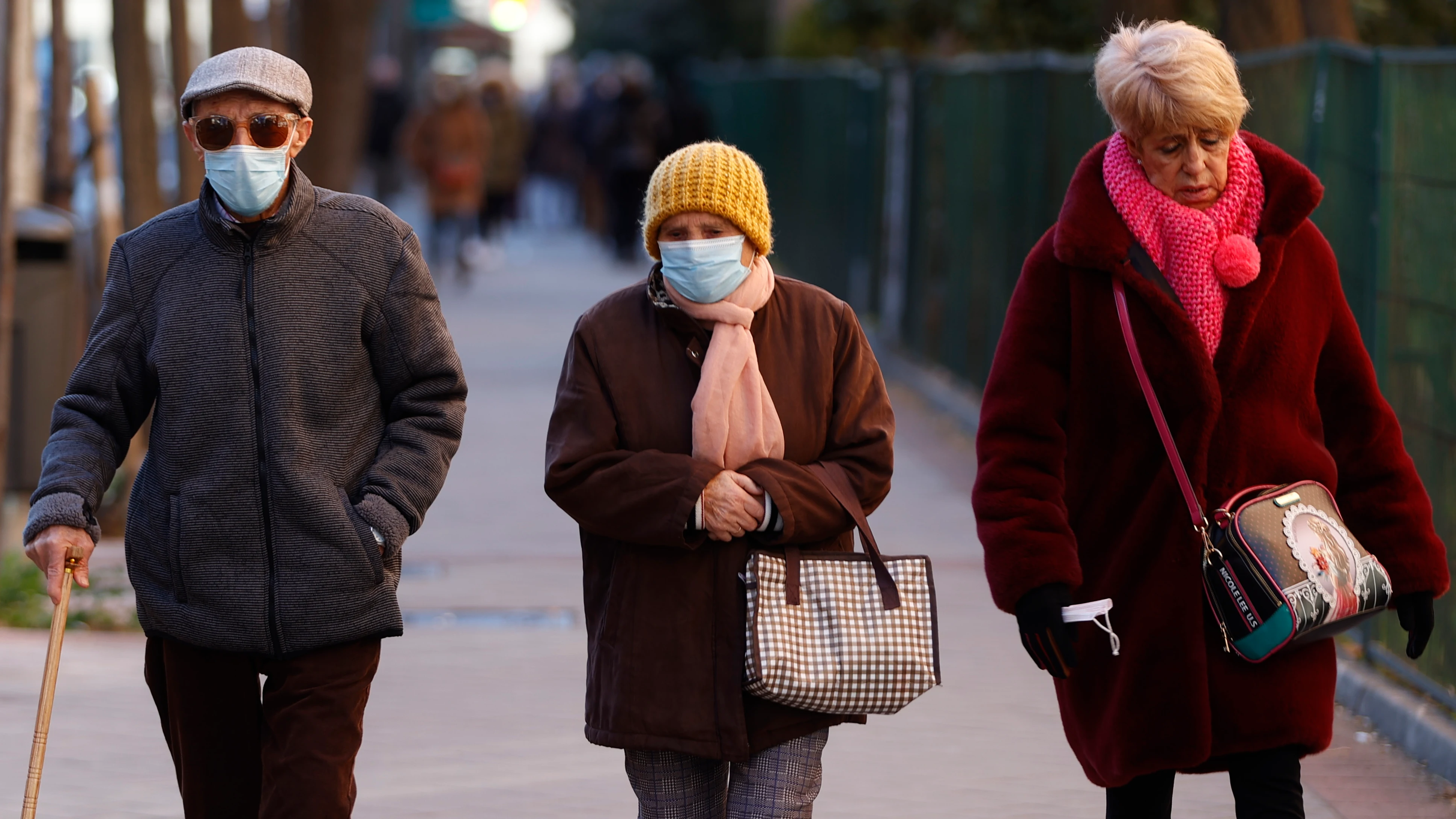 Tres personas pasean por las calles de Madrid