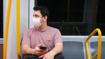 Joven con la mascarilla en el metro
