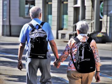 Hombre y mujer ancianos caminando juntos de la mano