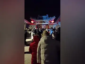 Unos turistas patalean la puerta de un templo en China por la ola de frío extremo que están viviendo