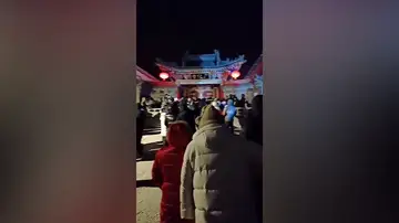 Unos turistas patalean la puerta de un templo en China por la ola de frío extremo que están viviendo