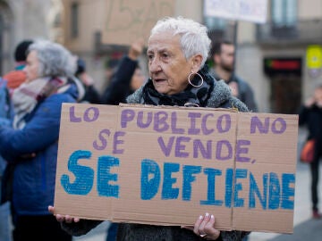 Una mujer se manifiesta en defensa de la Sanidad pública con la pancarta 'Lo público no se vende, se defiende'