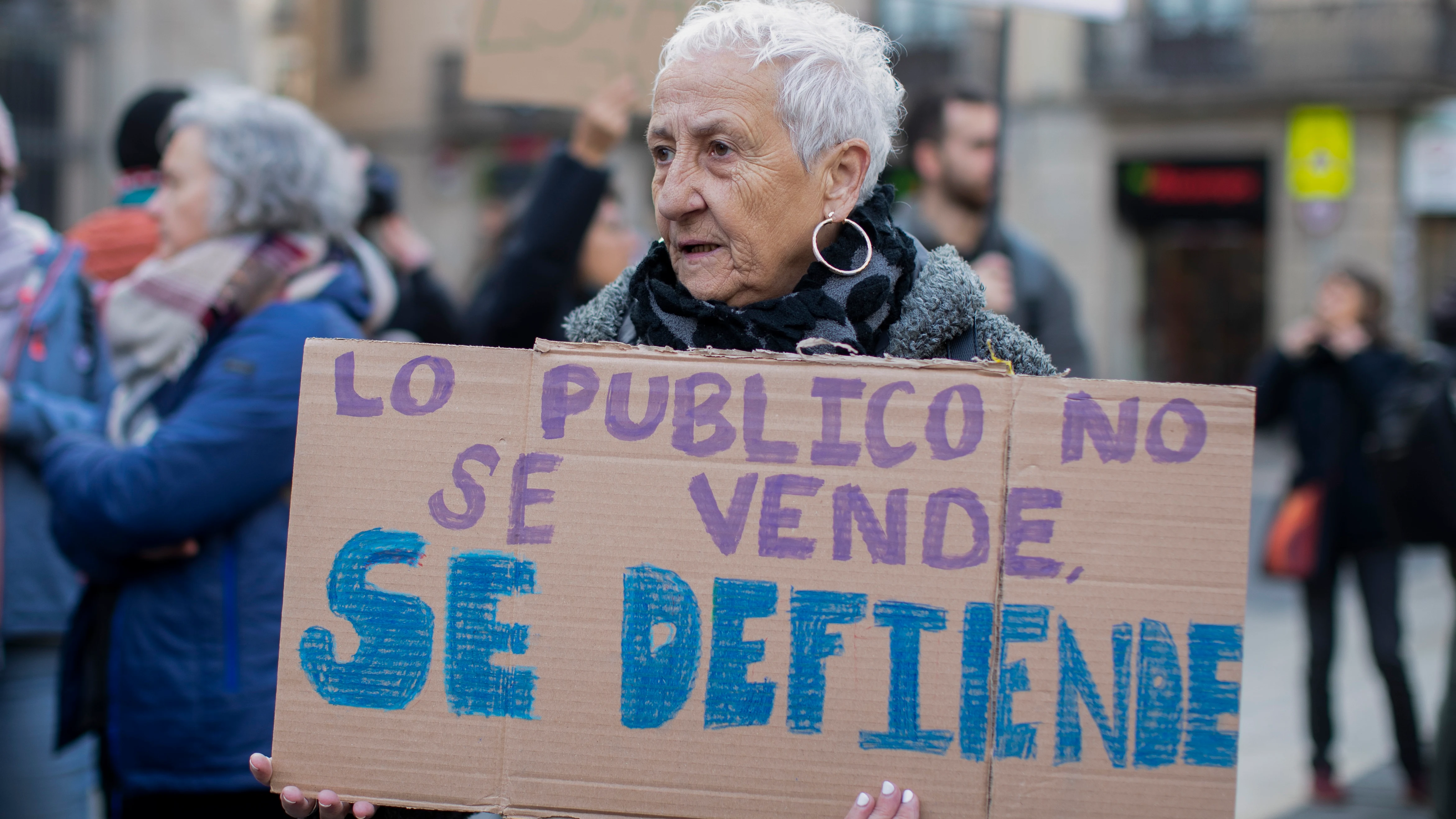 Una mujer se manifiesta en defensa de la Sanidad pública con la pancarta 'Lo público no se vende, se defiende'