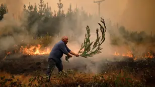 Un hombre lucha contra las llamas en los incendios que asolan Chile