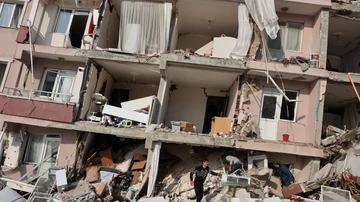 La gente mira entre los escombros mientras continúa la búsqueda de sobrevivientes tras el terremoto en Hatay, Turquía.