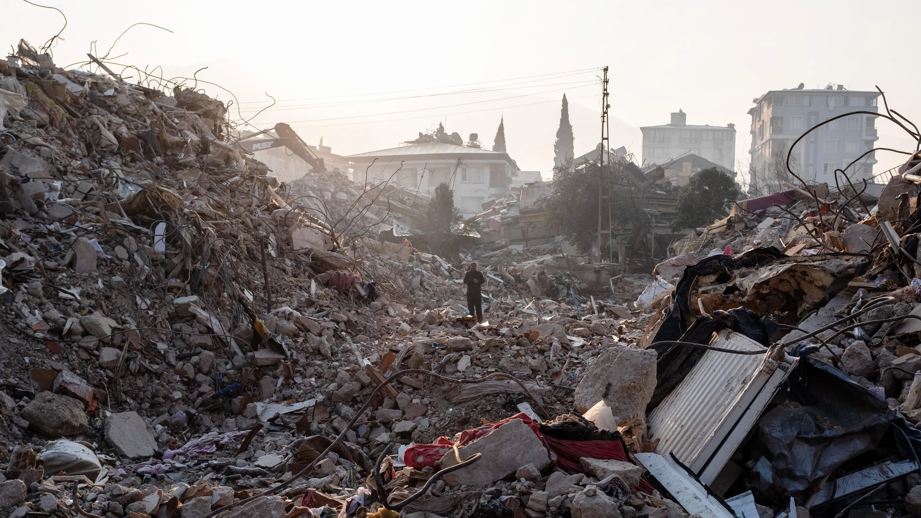 Un hombre camina entre los escombros de un edificio derrumbado mientras espera noticias de sus seres queridos el 13 de febrero de 2023 en Hatay, Turquía.