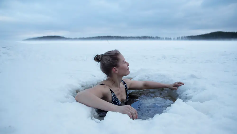 Joven bañándose en un lago helado en Finlandia