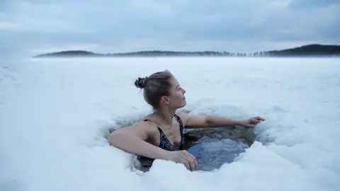 Joven bañándose en un lago helado en Finlandia Joven bañándose en un lago helado en Finlandia