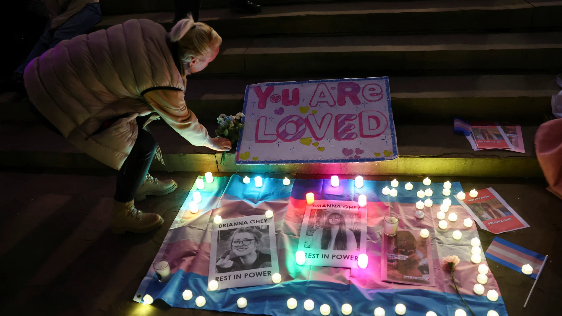 Una persona deposita flores en un altar en recuerdo de la menor trans asesinada Brianna Ghey.