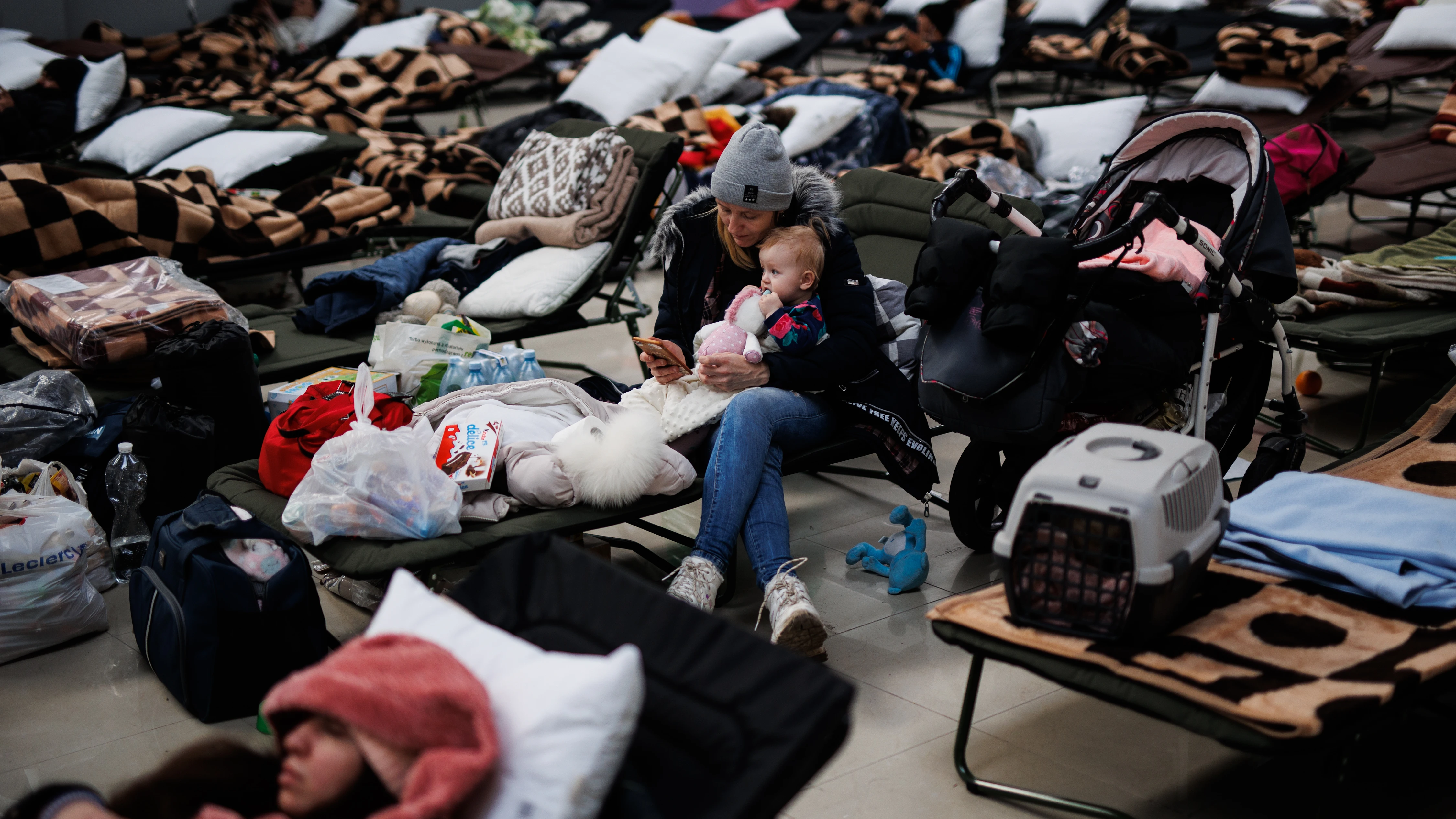 Una mujer con un bebé, en un centro comercial habilitado para los refugiados, en Mylny (Polonia)