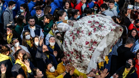 Un grupo de personas sujeta a una fallera en la Crida de las Falleras Mayores para dar comienzo a las Fallas en las Torres de Serrano. Un grupo de personas sujeta a una fallera en la Crida de las Falleras Mayores para dar comienzo a las Fallas en las Torres de Serrano.