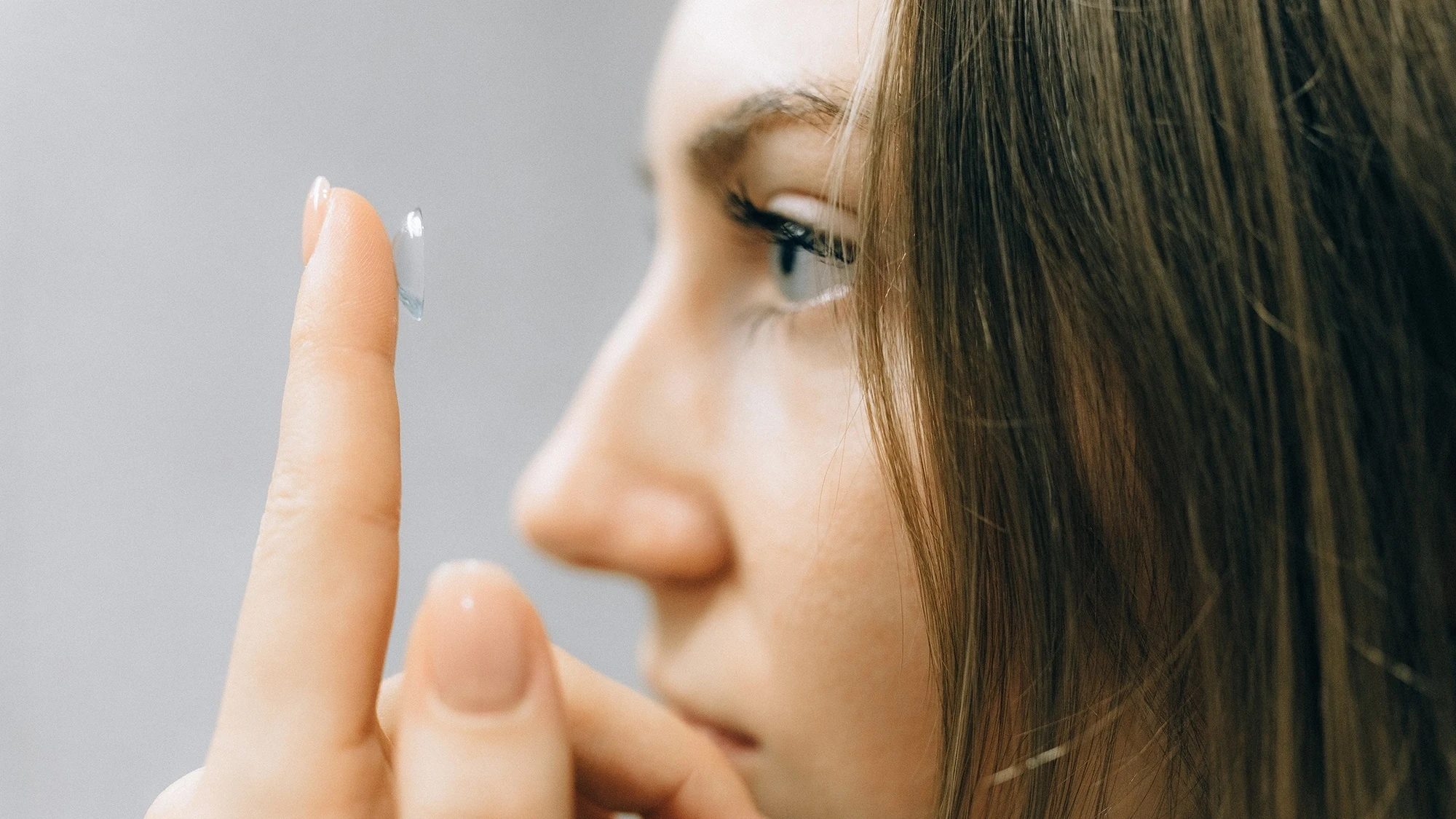 Imagen de archivo de una chica colocándose una lentilla ocular