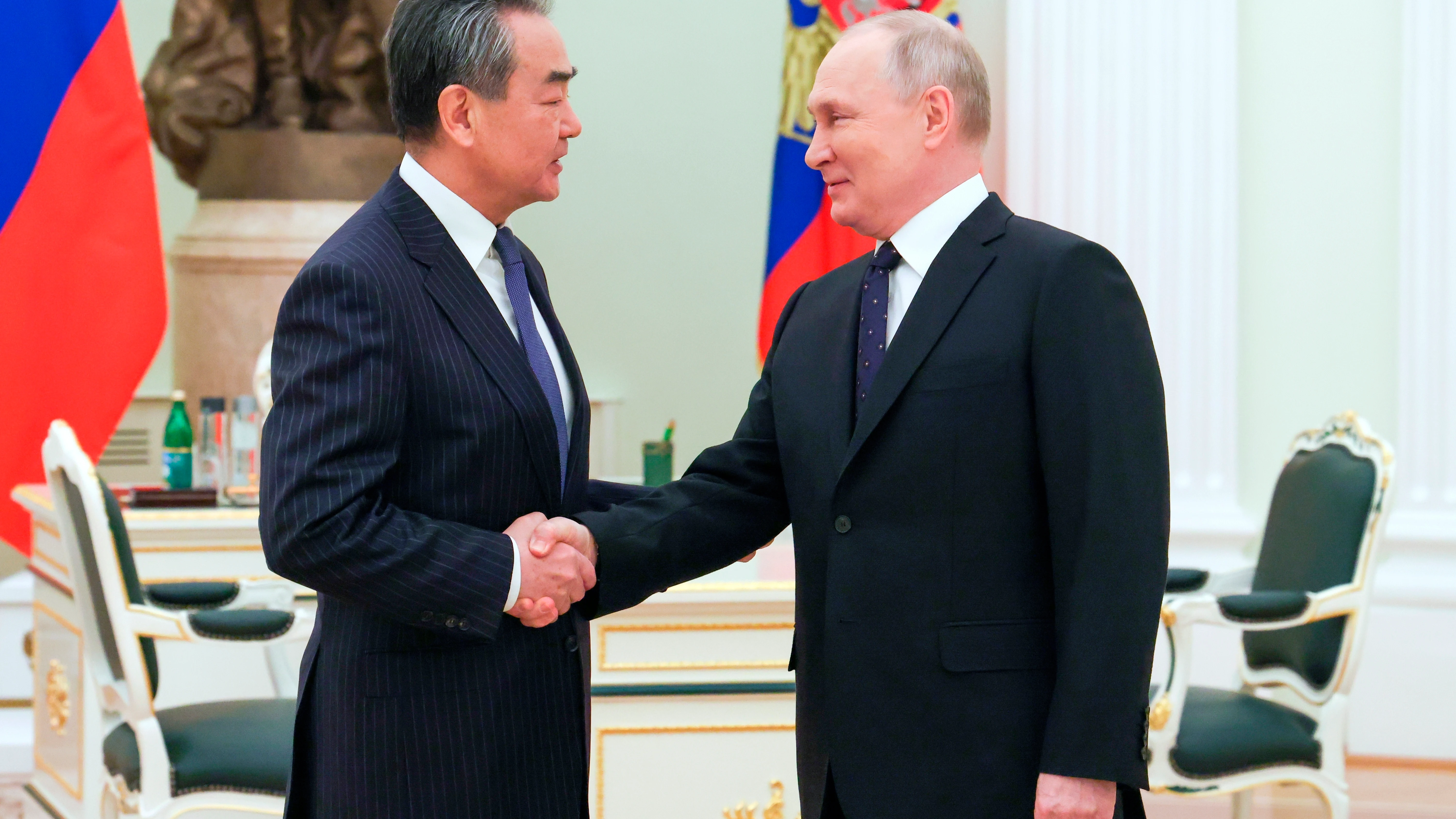 Vladimir Putin saluda a Wang Yi, jefe de la diplomacia china