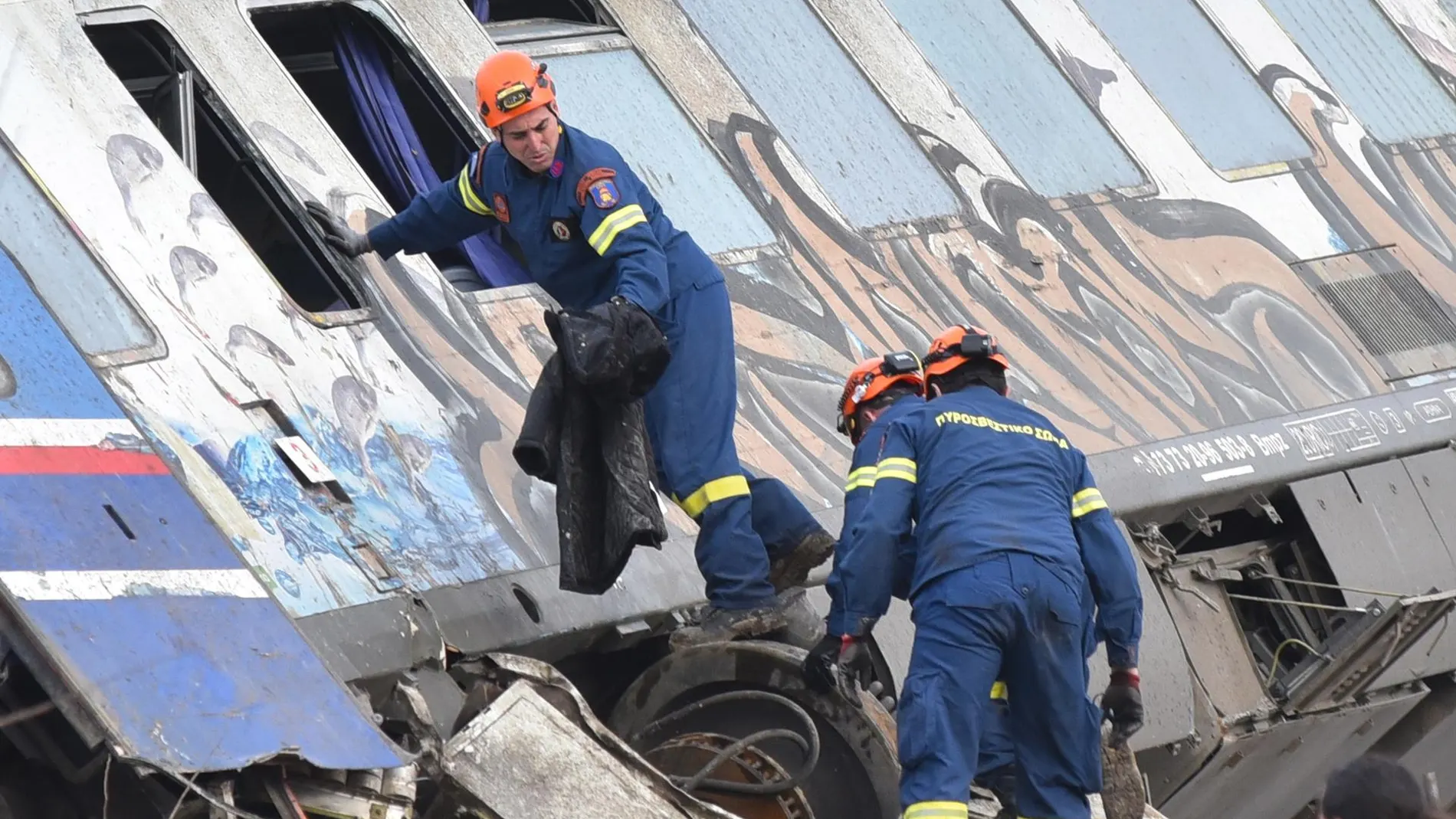 Los bomberos trabajan por recuperar supervivientes del accidente de trenes en Grecia dentro de los vagones.
