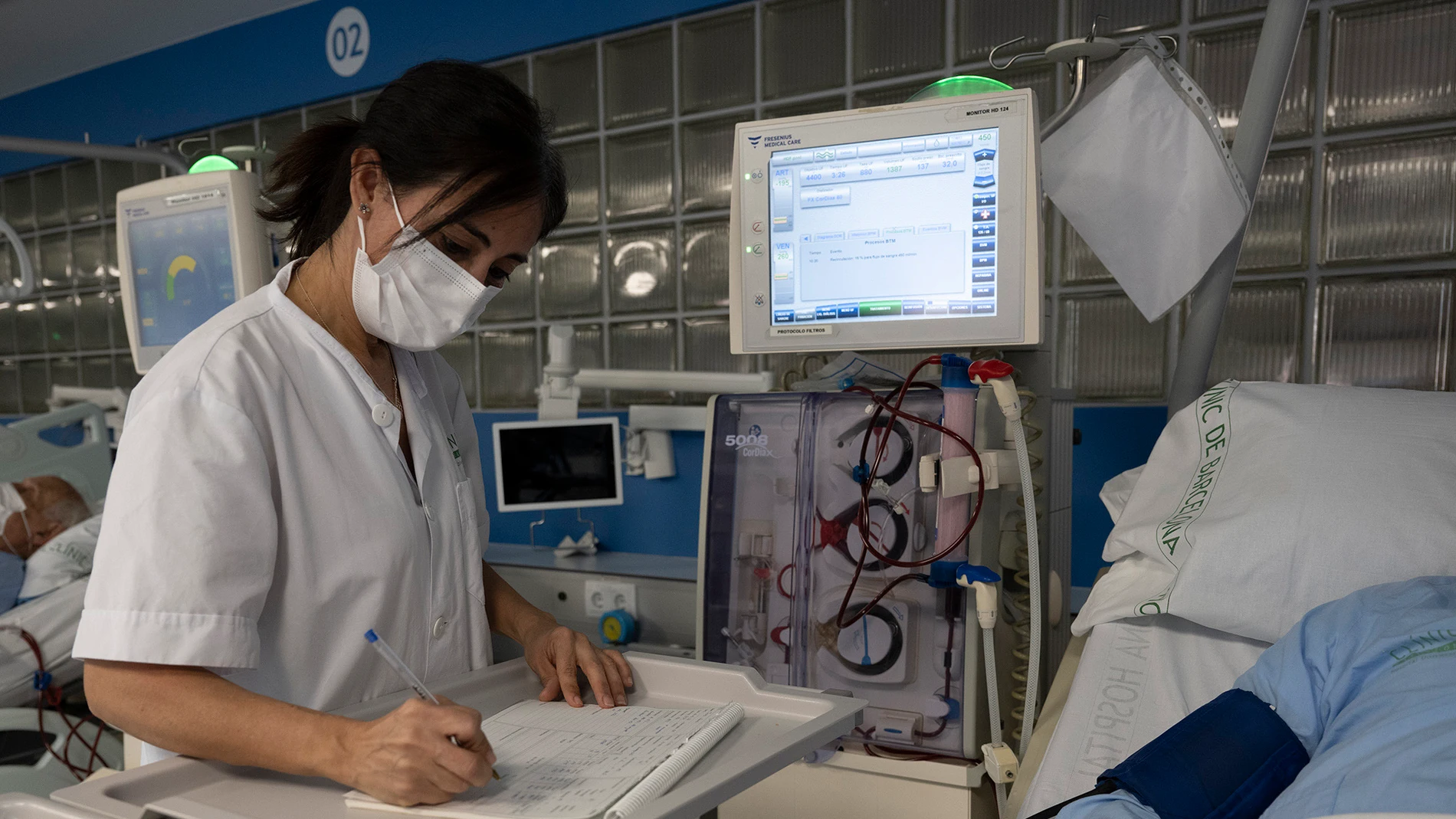 Una sanitaria del Hospital Clínic de Barcelona trabaja tomando notas a mano tras el ciberataque