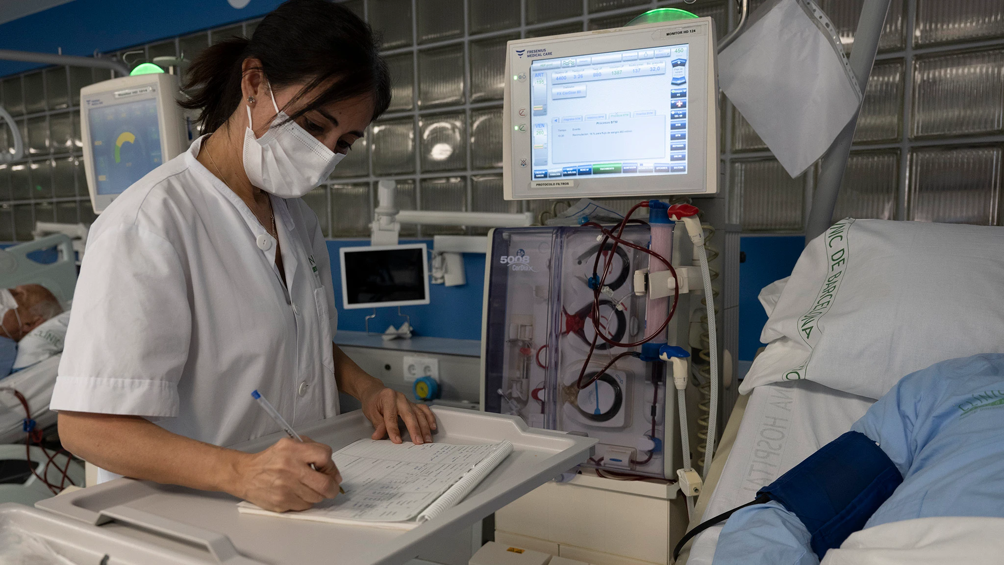 Una sanitaria del Hospital Clínic de Barcelona trabaja tomando notas a mano tras el ciberataque