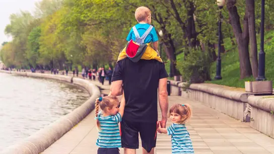 Un padre con sus tres hijos de paseo Un padre con sus tres hijos de paseo
