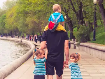 Un padre con sus tres hijos de paseo Un padre con sus tres hijos de paseo