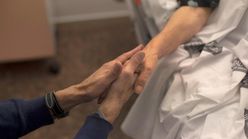 Imagen de archivo de las manos de una mujer acariciada por las de su marido minutos antes del proceso de eutanasia.