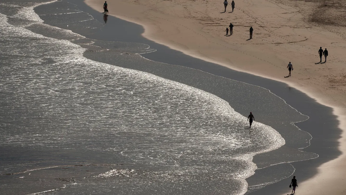 Varias personas pasean por la playa de La Concha en Suances. Varias personas pasean por la playa de La Concha en Suances.