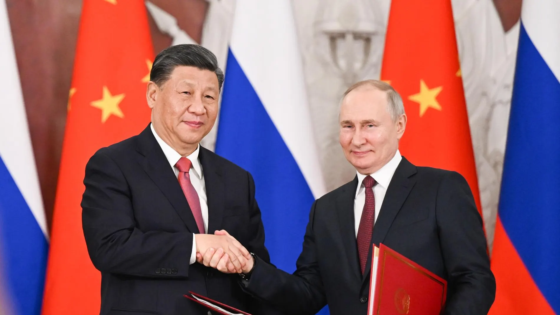 El presidente chino, Xi Jinping, y el presidente ruso, Vladimir Putin, se dan la mano tras firmar una Declaración Conjunta.