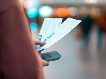 Viajero con billetes de avión en el aeropuerto Viajero con billetes de avión en el aeropuerto