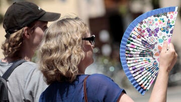 Dos personas combaten el calor con un abanico en Valencia