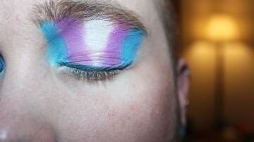 Un ojo con los colores de la bandera trans pintados