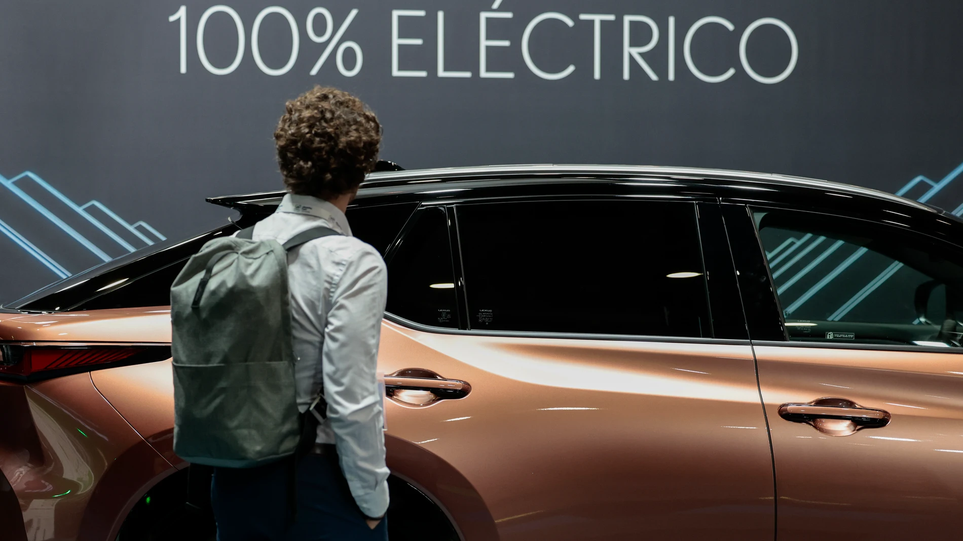 Una persona contempla un coche eléctrico en el eMobility Expo World Congress.