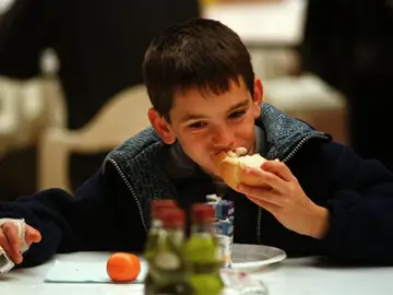 Un niño desayuna pan con aceite Un niño desayuna pan con aceite