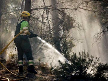 En la imagen, bomeros refrescan los alrededores de Montán
