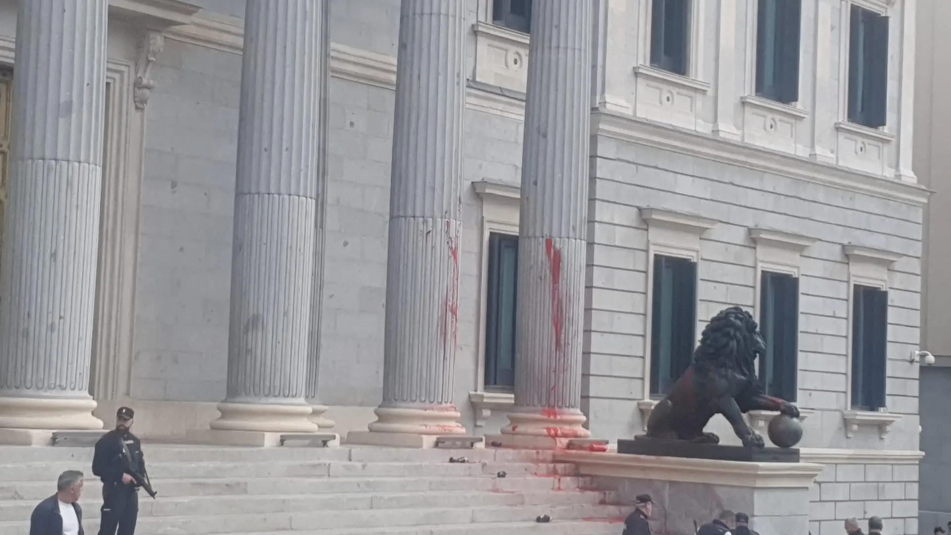 Imagen de la puerta del Congreso de los Diputados manchada de pintura roja.