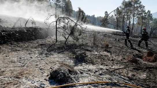 En la imagen, bomberos refrescan los alrededores de Montán. En la imagen, bomberos refrescan los alrededores de Montán.