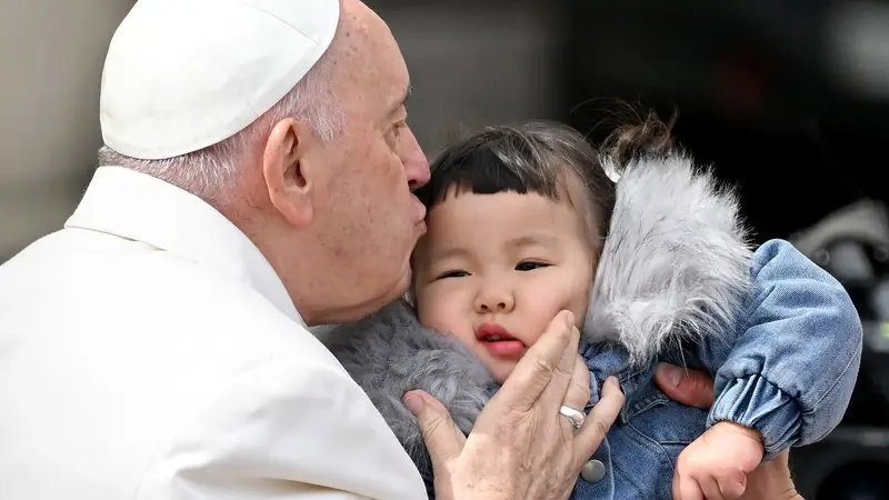 El Papa Francisco besa a un niño este miércoles al final de su audiencia general semanal en la Plaza de San Pedro.