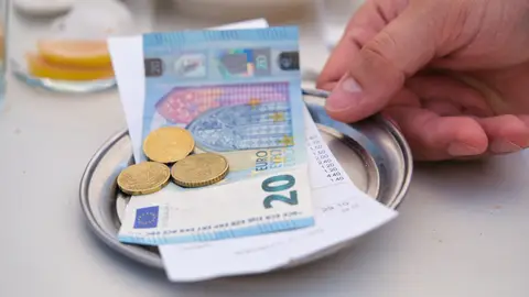 Dinero con propina y la cuenta de un bar Dinero con propina y la cuenta de un bar