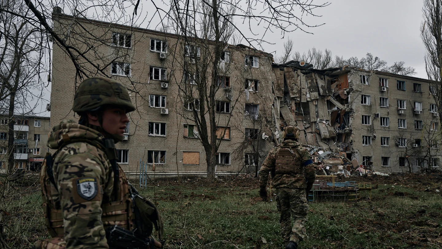 Soldados ucranianos pasan por un edificio de apartamentos dañado por el bombardeo ruso en Avdiivka, región de Donetsk. Soldados ucranianos pasan por un edificio de apartamentos dañado por el bombardeo ruso en Avdiivka, región de Donetsk.