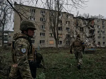 Soldados ucranianos pasan por un edificio de apartamentos dañado por el bombardeo ruso en Avdiivka, región de Donetsk.
