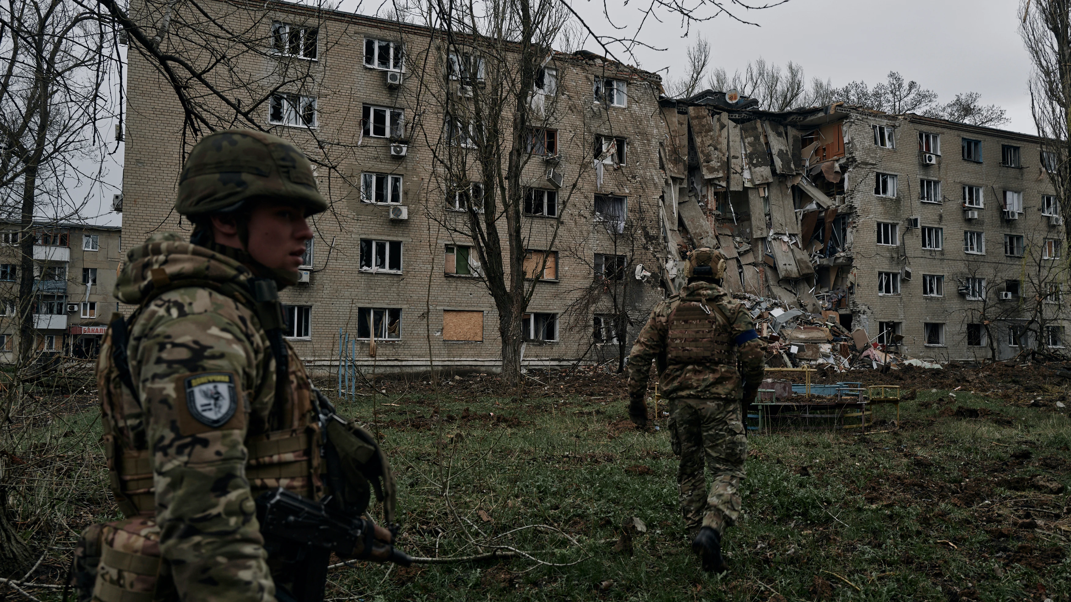 Soldados ucranianos pasan por un edificio de apartamentos dañado por el bombardeo ruso en Avdiivka, región de Donetsk.