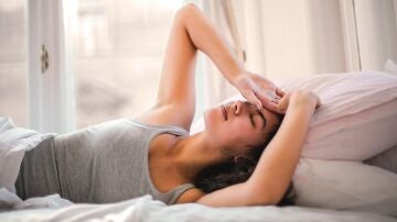 Una mujer con dolor de cabeza al despertar