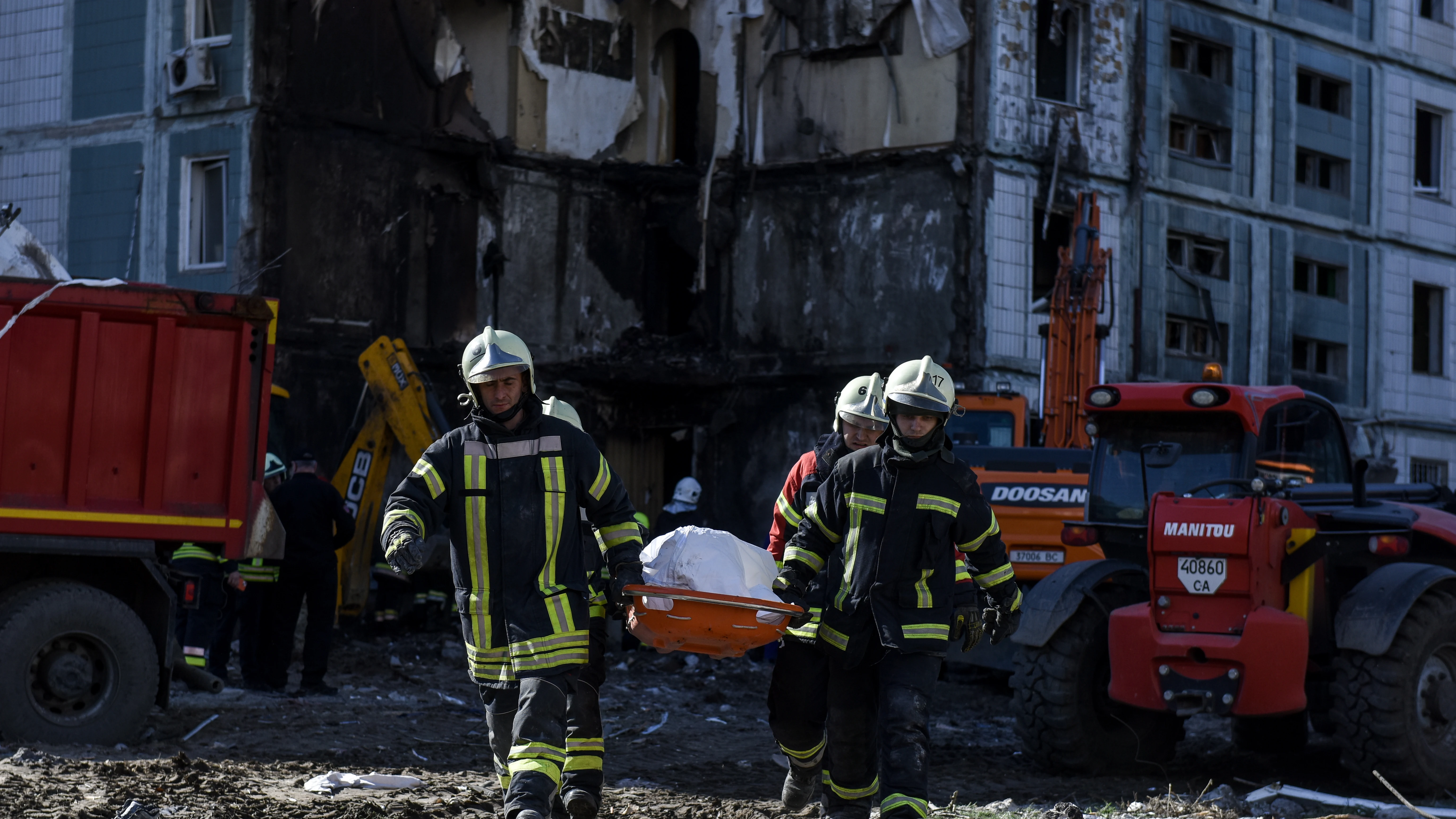 Los rescatistas llevan un cuerpo recuperado en el sitio de un edificio residencial dañado después de un ataque con misiles, en Uman, región de Cherkasy, Ucrania central, el 28 de abril de 2023.