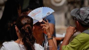 Una turista se protege con un abanico mientras pasea por el centro de Córdoba