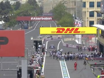 Esteban Ocon se encuentra a los fot&oacute;grafos en boxes.