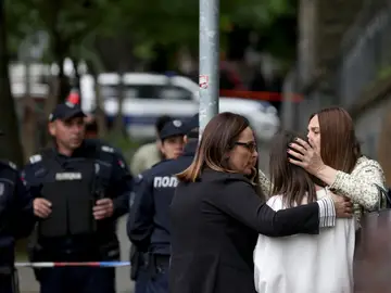 Profesoras consuelan a una estudiante tras el tiroteo en Belgrado