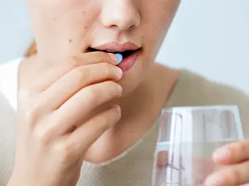 Una mujer tomando medicamentos Una mujer tomando medicamentos