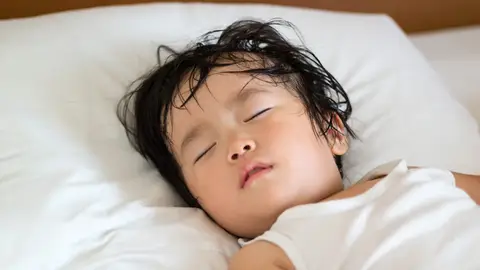 Niña sudando mientras duerme Niña sudando mientras duerme