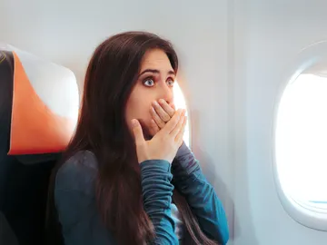 Mujer asustada en el avión Mujer asustada en el avión