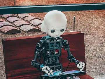 Un robot ojeando una tableta Un robot ojeando una tableta