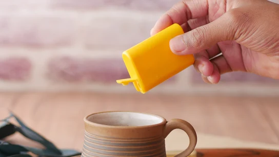 Imagen de archivo de una taza de café y un envase de edulcorantes Imagen de archivo de una taza de café y un envase de edulcorantes