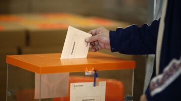 Fotografía de una urna en la que se está depositando un voto